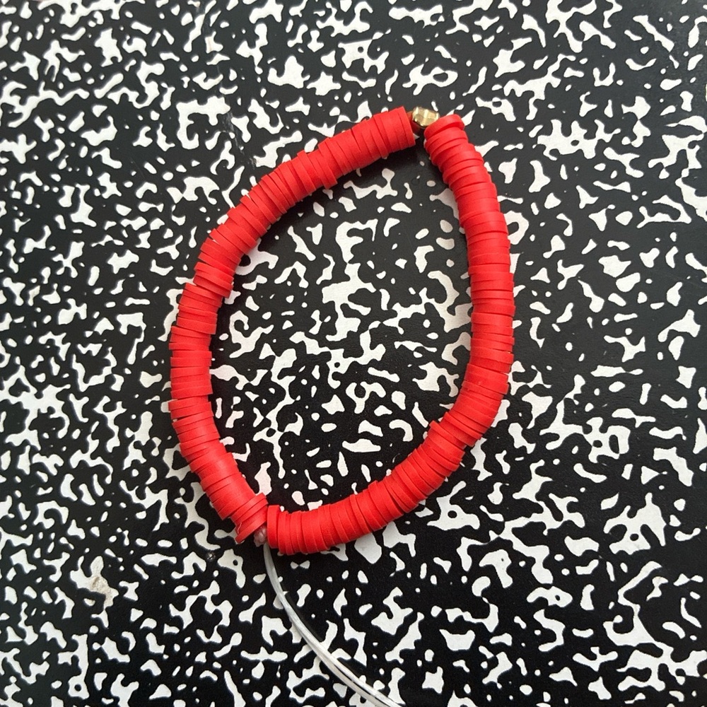 Red bracelet and red and black bracelet and blue and orange bracelet